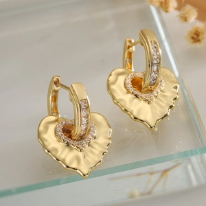 Golden heart earrings with hammered metal texture and sparkling cubic zirconia stones