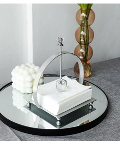 Silver metal tissue holder detail with a crystal weighted arm on a mirrored tray