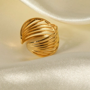 18K gold-plated multilayer crisscross stainless steel ring on beige silk fabric
