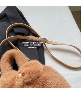 Close-up of brown plush bucket bag with adjustable leather strap and silver buckle detail