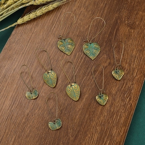 Boucles d'oreilles bohèmes vintage en bronze avec texture patinée sur fond de bois