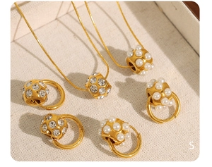 Détails du collier en perles dorées et boucles d'oreilles créoles avec cristaux brillants