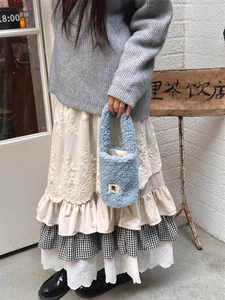 Close-up of a soft light blue plush tote bag with a cute cartoon label for winter