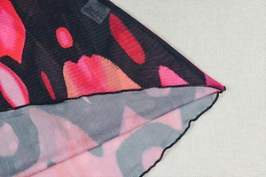 Detail of artistic abstract floral mesh fabric with high-quality edge stitching and label