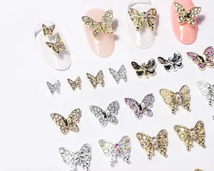 Macro detail of 3D butterfly nail charms with rhinestones and pearls on metal base