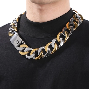 Close-up of a wide chunky two-tone Cuban link necklace on model with large metal clasp