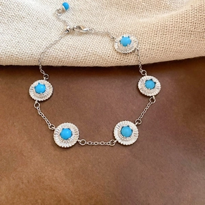 Détail d'un bracelet vintage argenté avec pierres de résine turquoise et fermoir mousqueton