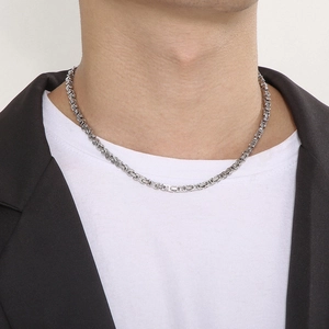 Close-up of a 4mm silver Byzantine chain necklace worn by a male model for a hip-hop look