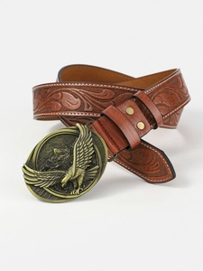 Detail of vintage eagle brass buckle and embossed floral pattern on brown leather belt