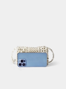 Detailed view of a white beaded crossbody bag showing scale next to a smartphone