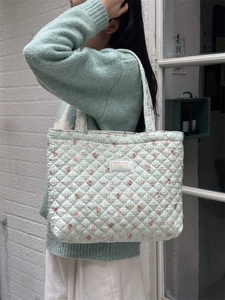 Close-up of quilted cotton tote bag with cute rabbit prints and woven brand label