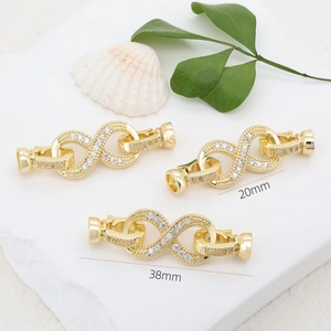 18K gold plated infinity jewelry clasp with white zircons on a natural stone background