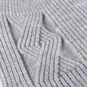 Close-up of a warm grey winter beanie showing thick jacquard knit and wool texture