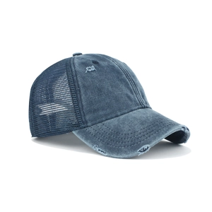 Detail of navy blue washed denim baseball cap featuring vintage distressed holes and mesh back