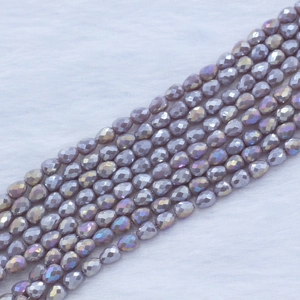 Macro view of purple faceted strawberry teardrop glass beads with iridescent coating