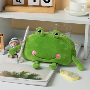 Close-up of green plush frog pencil case with zipper closure on a minimalist desk