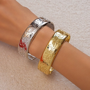 Detail showing vintage embossed swirl patterns on gold and silver oval bangles