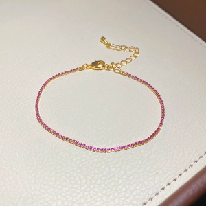 Detail view of pink cubic zirconia tennis bracelet with gold chain and lobster clasp