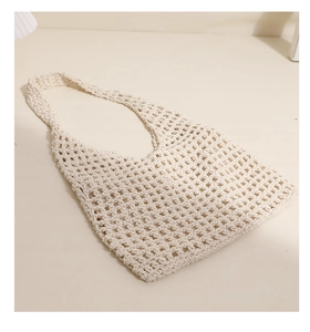 Close-up of cream white hollow-out cotton weave texture on a summer beach tote bag