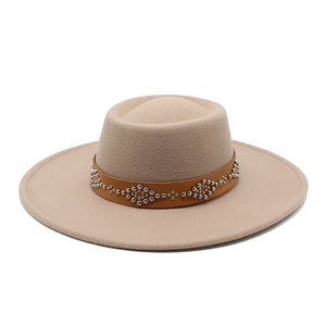 Detail of beige fedora hat with brown leather band and silver wave-patterned rivets