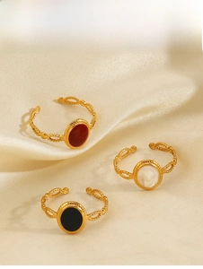 Three gold oval rings with red, white, and black drip oil finish on silk fabric