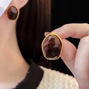 Macro shot of irregular amber resin earrings with gold twisted edge detail