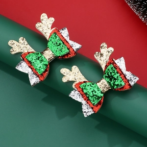 Detail of Christmas reindeer antler hair clips with glitter sequins and festive bow design