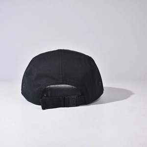Detail of adjustable nylon strap and plastic buckle on black 5-panel canvas camper hat