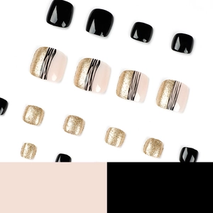 Zomerse kunstnagels voor tenen met zwarte strepen en gouden glitters design.