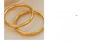 Polished 18K gold plated titanium steel rings on elegant beige leather texture background