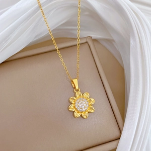 Close-up of golden sunflower pendant necklace with sparkling rhinestones on silk