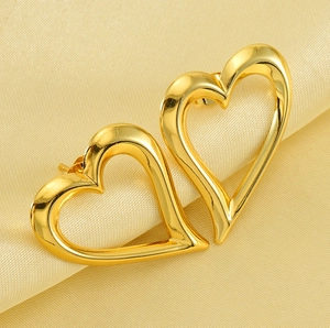 Vista macro di orecchini a cuore cavo in oro 18 carati su elegante sfondo di seta