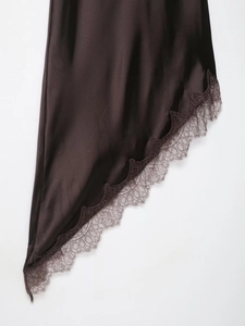 Détail d'une robe en satin marron foncé avec dentelle délicate et texture soyeuse lisse