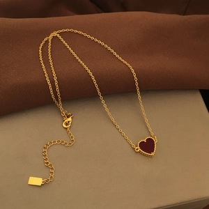 Elegant gold-plated necklace featuring a red resin heart pendant with beaded metal edges