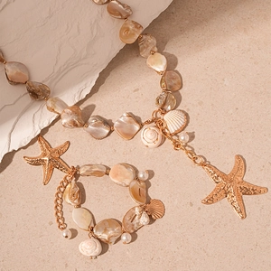 Ocean style necklace and bracelet set with sea shells, golden starfish and conch charms