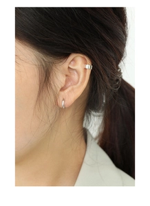 Close-up of a silver ear cuff and hoop earring set in minimalist S925 sterling silver
