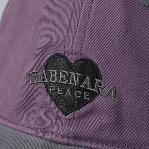 Detail of heart embroidery and PEACE text on washed cotton baseball cap fabric