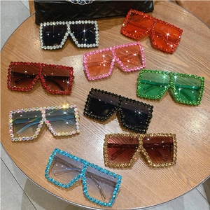 Flat lay of oversized square sunglasses with sparkling diamond frames in various colors