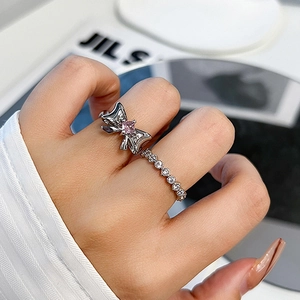 Pink diamond bow open ring and gold pave band on model hand with minimalist style