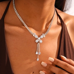 Detail of silver butterfly pendant necklace with zircon tassels on a model's neck