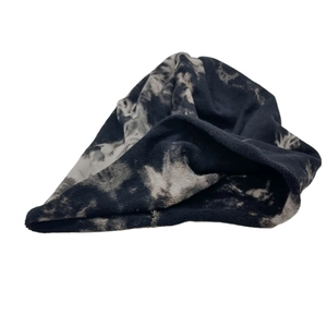 Detail of soft tie-dye knit beanie in black, grey and white with rolled edge texture