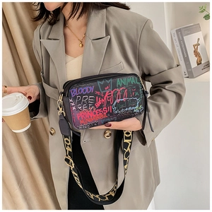 Close-up of graffiti crossbody bag with colorful text prints and jacquard wide strap