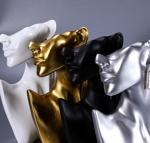 Close-up of elegant resin mannequin busts in gold, silver, black, and white for jewelry