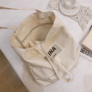 Détail du grand sac cabas en toile épaisse kaki avec imprimé INA sur fond matelassé
