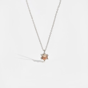 Macro shot of silver S925 necklace with champagne round-cut zircon pendant on white background