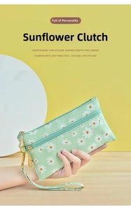 Detail of mint green wristlet bag featuring a daisy pattern and secure zipper strap