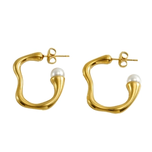 Detailed view of wave-shaped irregular golden hoop earrings with white pearl accents