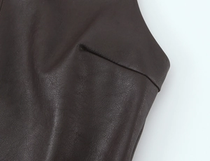 Nahaufnahme der feinen Nähte und Narbenstruktur auf dunkelbraunem Leder-Jumpsuit-Kleid
