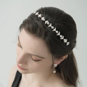 Detailed view of an elegant headband with alternating pearls and V-shaped silver metal elements