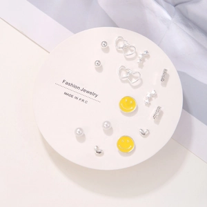 7-day silver stud earring set with stars, hearts, and smiley faces on a display card